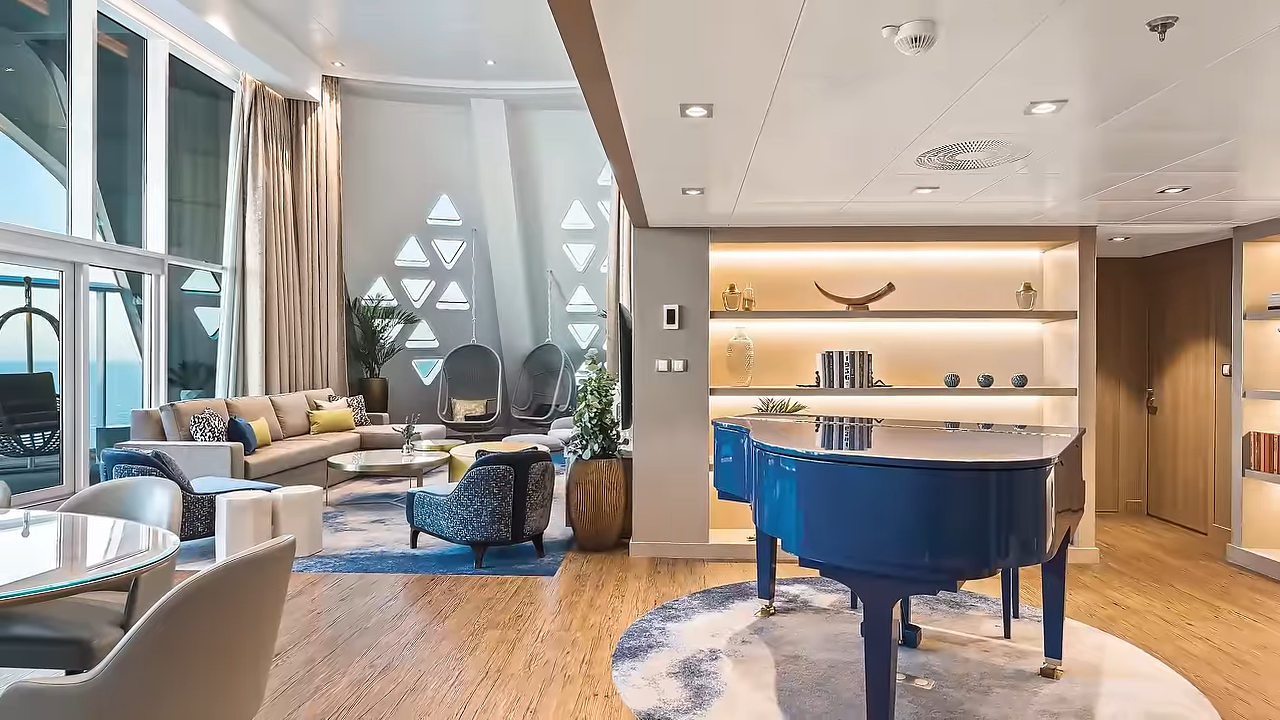 "Modern two-story living room area in a Royal Caribbean Star Class suite featuring a spiral staircase and ocean views."